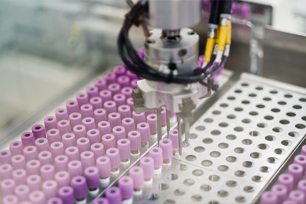 Robotic arm picking up test tube from tray